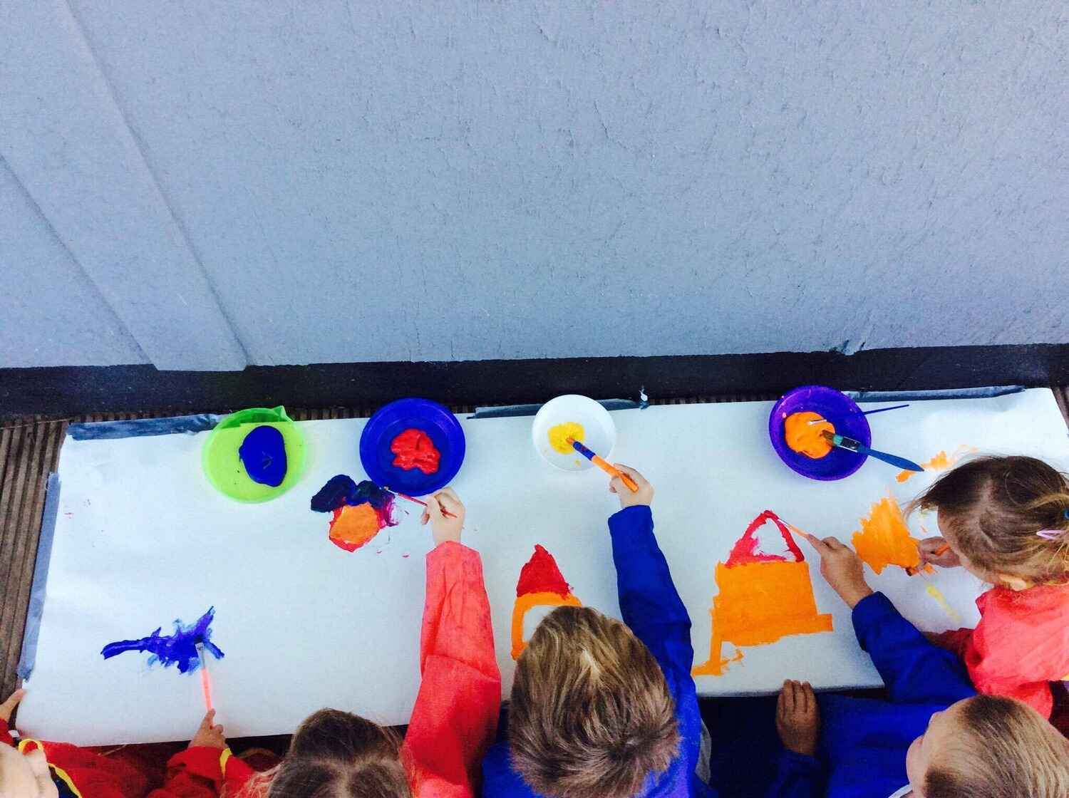children painting communal artwork